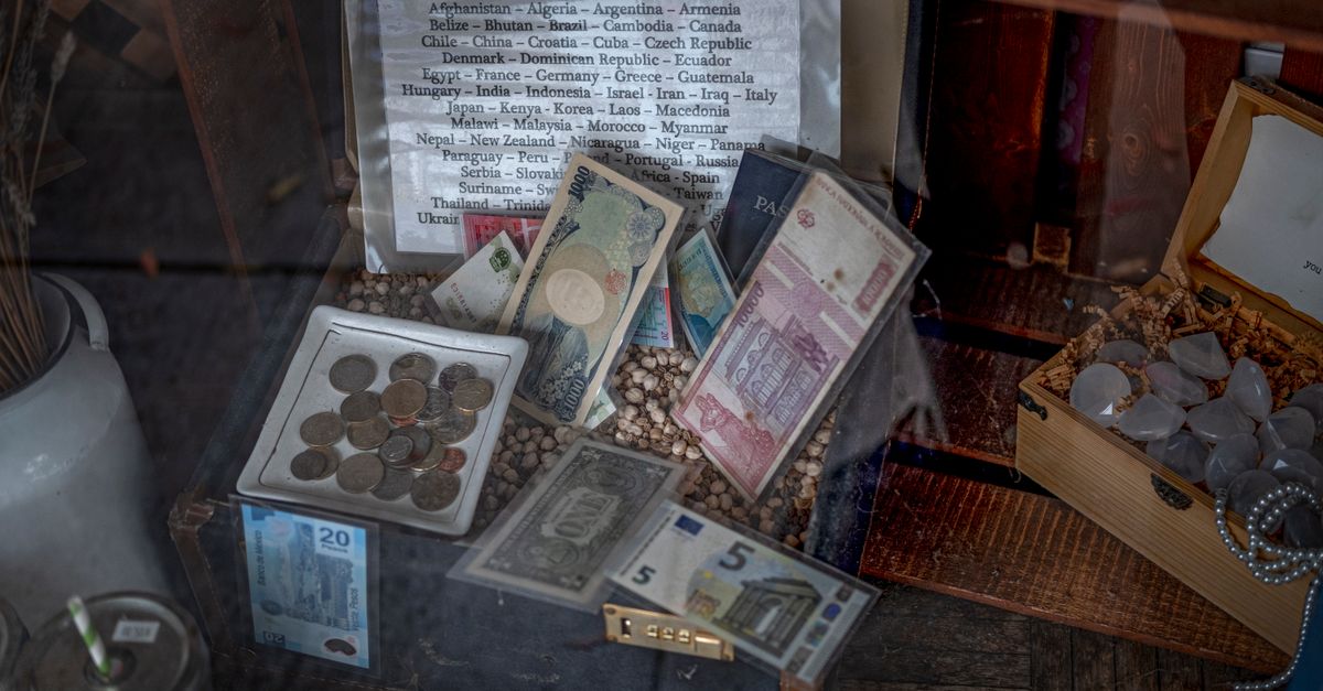 A diverse collection of global coins and banknotes displayed in a vintage setting.